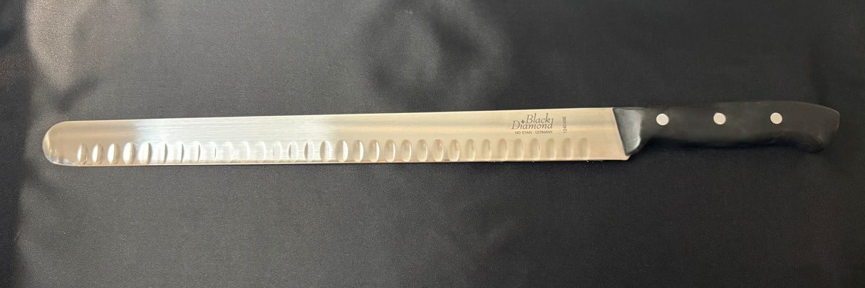 Serrated carving and slicing knife with steel blade and black handle, side view