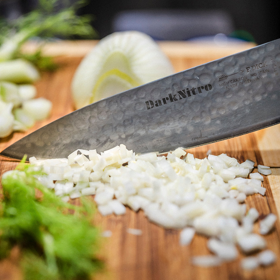 DarkNitro chef knife blade cutting chopped onions, close-up