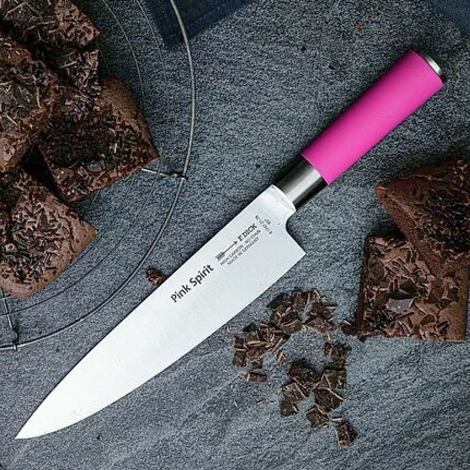 Pink Spirit chef knife diagonally on gray surface, pink handle visible