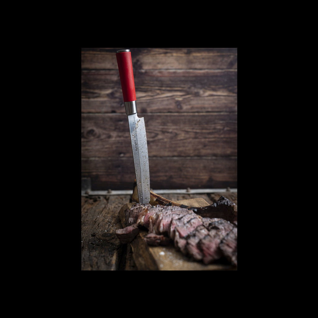 Sliced steak with a knife on a wooden surface