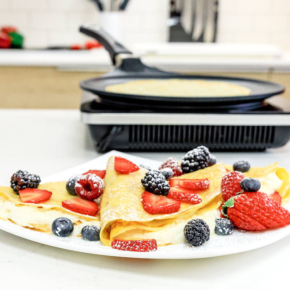 AMT crepes pan and fruit-topped crepe on a white plate