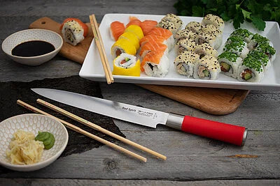 Sushi knife with red handle and long blade, near assorted sushi on tray