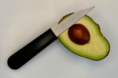 3-inch paring knife with textured black handle next to halved avocado
