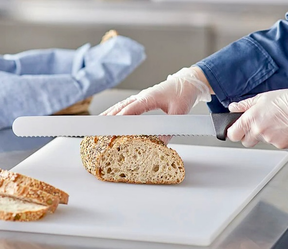 F.DICK Eurocut serrated bread knife with black handle, slicing a loaf on a board