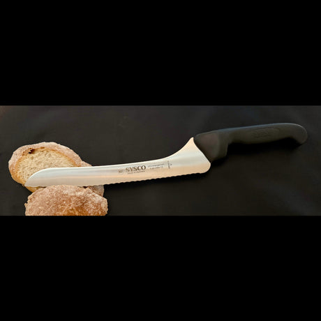 Offset bread knife with serrated blade resting on crusty bread
