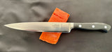 7-inch filleting knife on salmon cut, black handle with white rivets