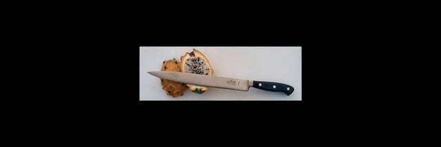 Kitchen slicer knife with black handle and stainless blade, next to sliced food