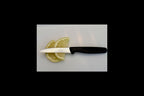 Knife with a black handle and visible brand name on a white surface with lemon slices.