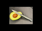Half-cut avocado with a knife on a gray surface