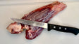F.Dick semi-flex boning knife with black handle and curved steel blade, on cutting surface