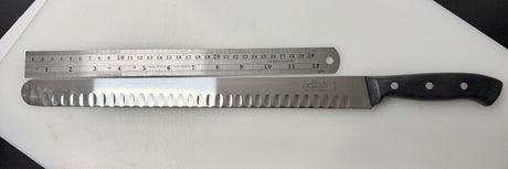 Serrated carving slicer knife with steel blade, black handle, and ruler-style markings