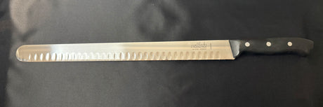 Serrated carving and slicing knife with steel blade and black handle, side view