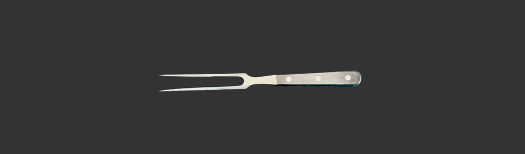 Metallic carving fork on a gray background