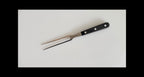 Black-handled carving fork on a white background