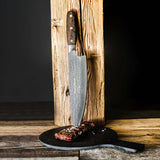 Chef knife standing in a wooden block with DarkNitro textured blade and oak handle