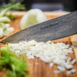 DarkNitro chef knife blade cutting chopped onions, close-up