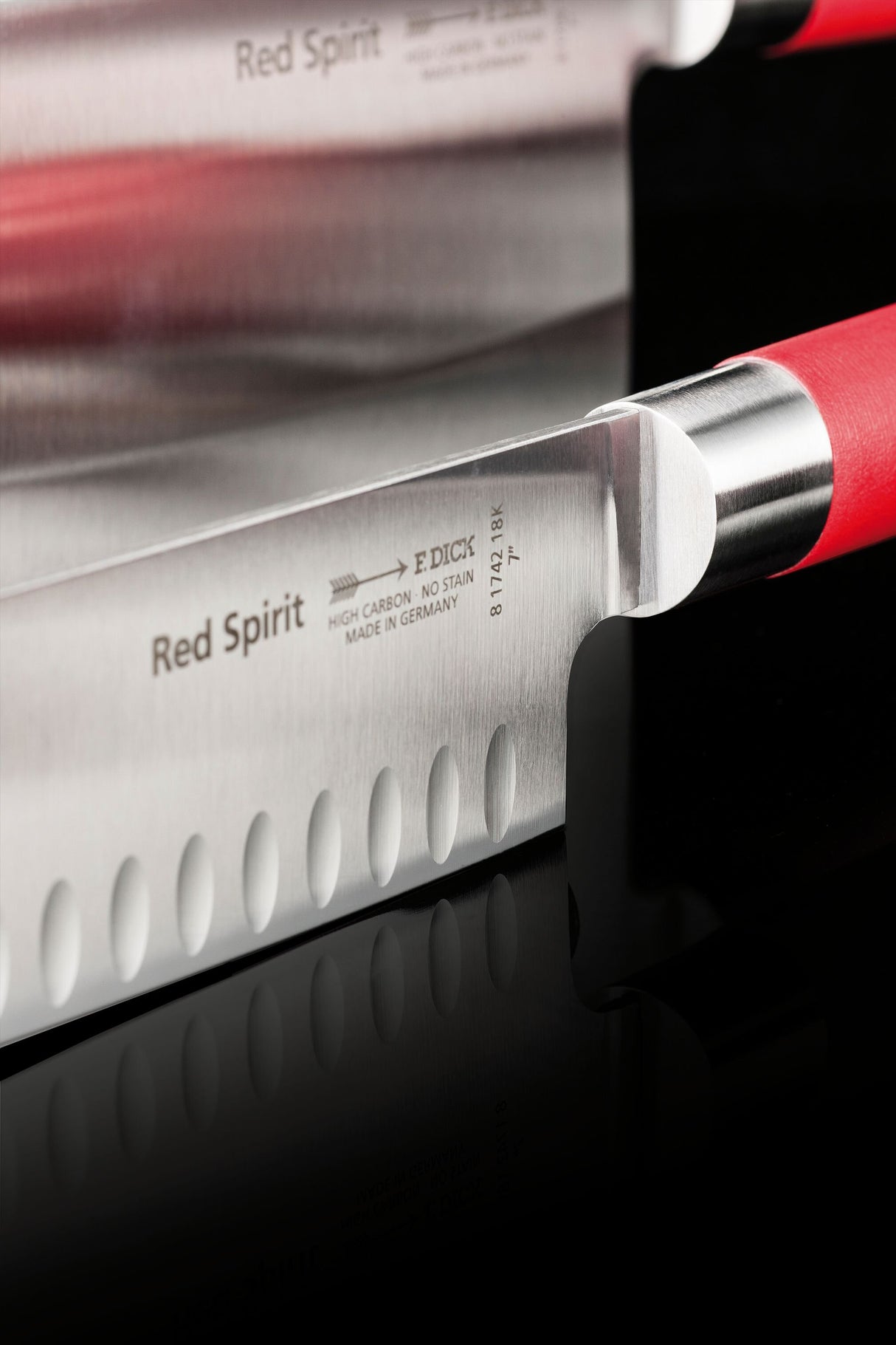 Red-handled Santoku knife with dimpled blade close-up