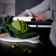F.Dick Usuba knife with red handle slicing cabbage on cutting board, white blade