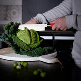 F.Dick Usuba knife with red handle slicing cabbage on cutting board, white blade