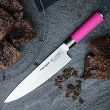 Pink Spirit chef knife diagonally on gray surface, pink handle visible