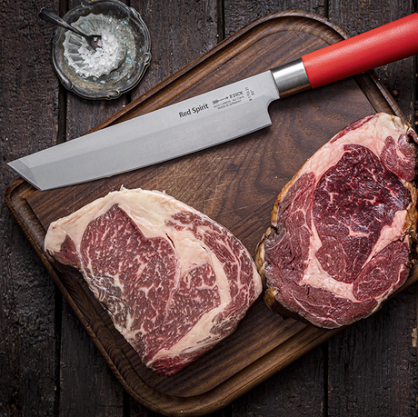 F.Dick Red Spirit chef knife with red handle and silver blade on a wooden board