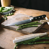 Chef knife with black striped handle and stainless blade on a cutting surface