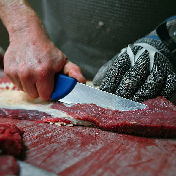 Deboning knife with blue handle slicing raw meat
