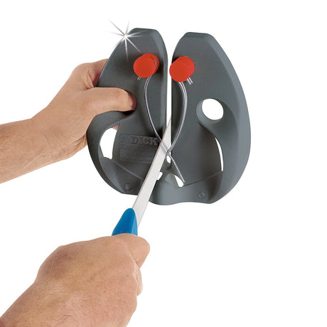 Black knife sharpener with red knobs, hands holding blade on sharpening tool