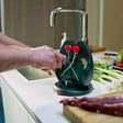 Green and black knife sharpener stand with red knobs and steel guide arms