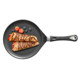 AMT crepes pan with folded crepes and berries on the black cooking surface