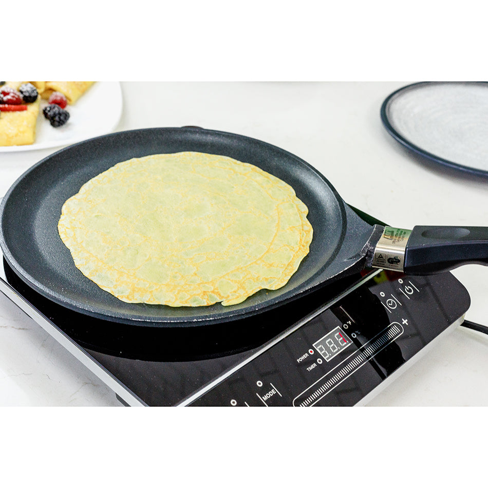 AMT crepes pan holding a thin crepe on the black nonstick surface