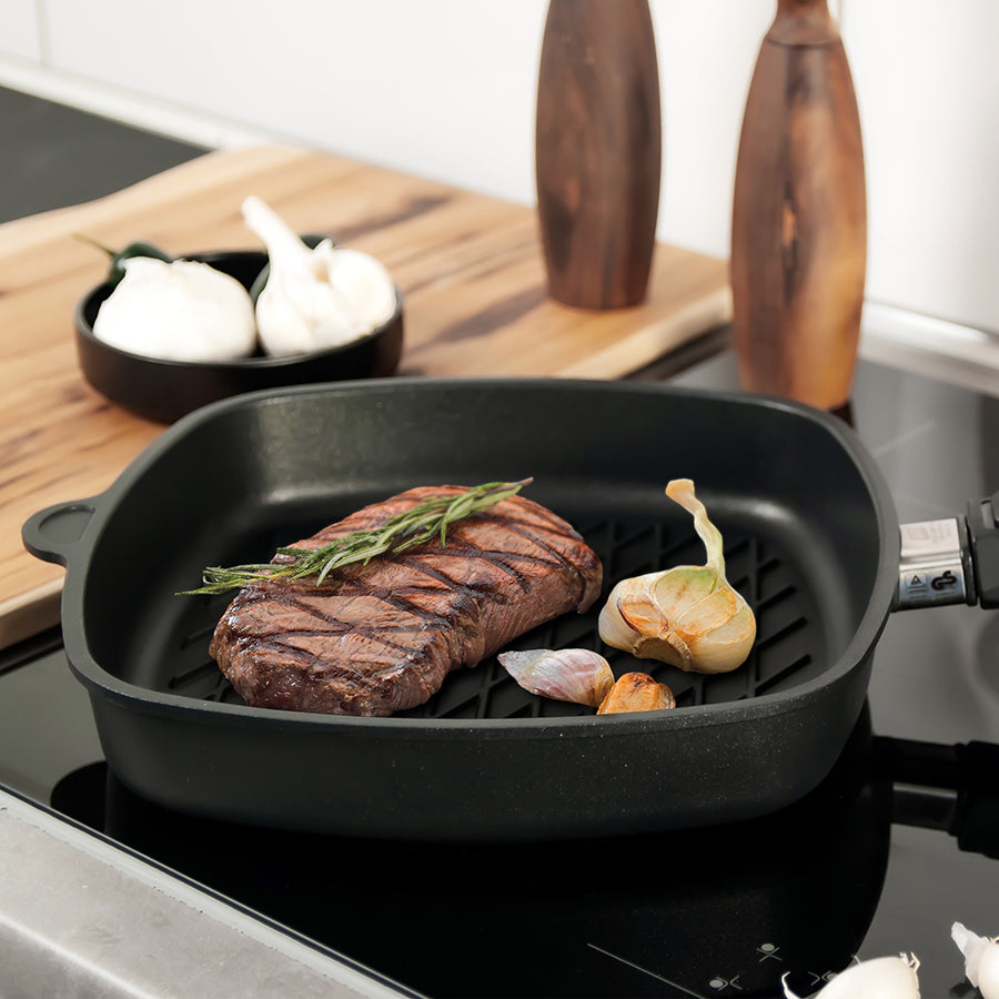 Square black grill pan with side handles and diamond-grill surface