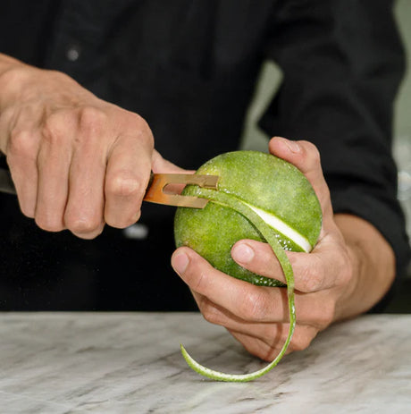 F. DICK channel knife with yellow blade trimming green fruit