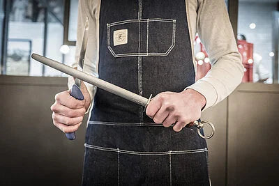 DICKORON knife held by a chef with red handle and silver blade