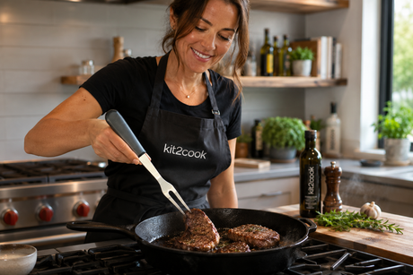 Chef holding a kitchen fork with two tines while cooking in a skillet