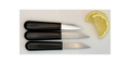 Three small knives with black handles on a white surface next to a lemon wedge.